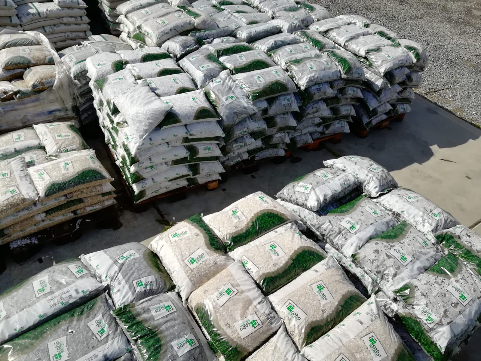 Sfeerbeeld met opgestapelde zakjes siergrind in het tuincentrum